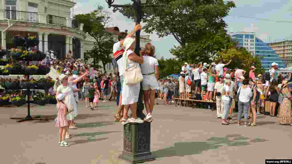 Люди залезли на фонарь для лучшего обзора