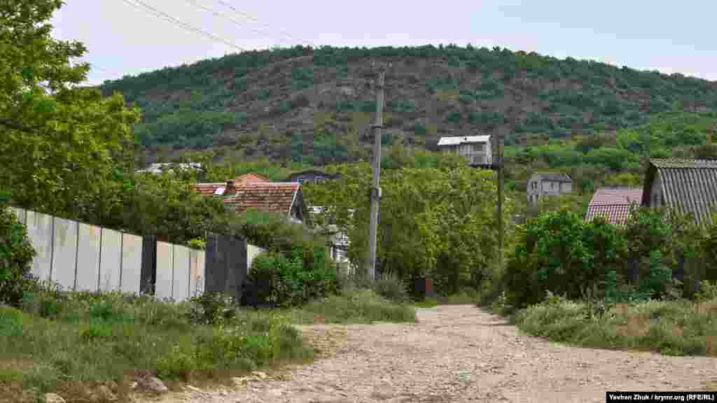 Домики как бы взбираются на склон горы Каю