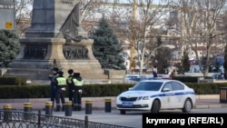 В Севастополе полиция усиленно патрулирует площадь Нахимова, чтобы не допустить акцию в поддержку Алексея Навального. Автомобиль и наряд ДПС стоят у памятника Нахимову, 30 января 2021 года