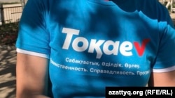 Қазақстан президенттігіне кандидат Қасым-Жомарт Тоқаевты қолдауға шақыратын жазуы бар жейде киіп №9 мектеп-гимназия ауласында жүрген адам. Ақтөбе, 16 мамыр 2019 жыл.