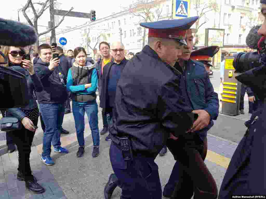 Полиция &quot;Наурыз мейрамын тойлауға келген&quot; адамды әкетіп барады.&nbsp;