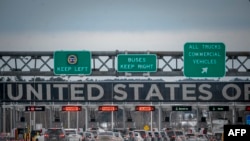 Cars wait in line to enter the United States at a border crossing at the Canada-US border.