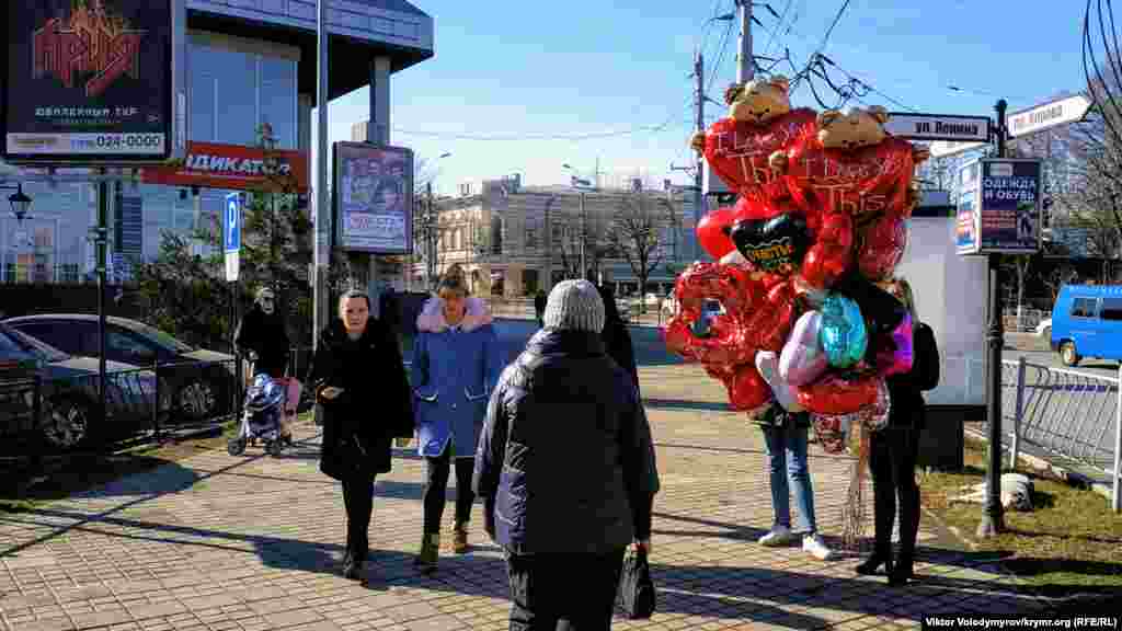 Девушка продает воздушные шары.&nbsp;Средняя цена одного шара в виде сердца составляет 200 рублей (80 грн)